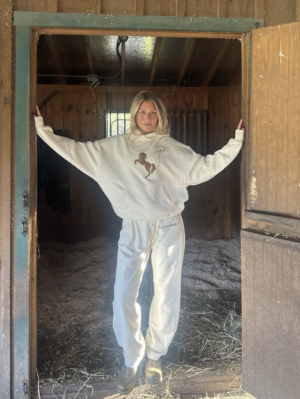 Cream horse hoodie in the barn doorway